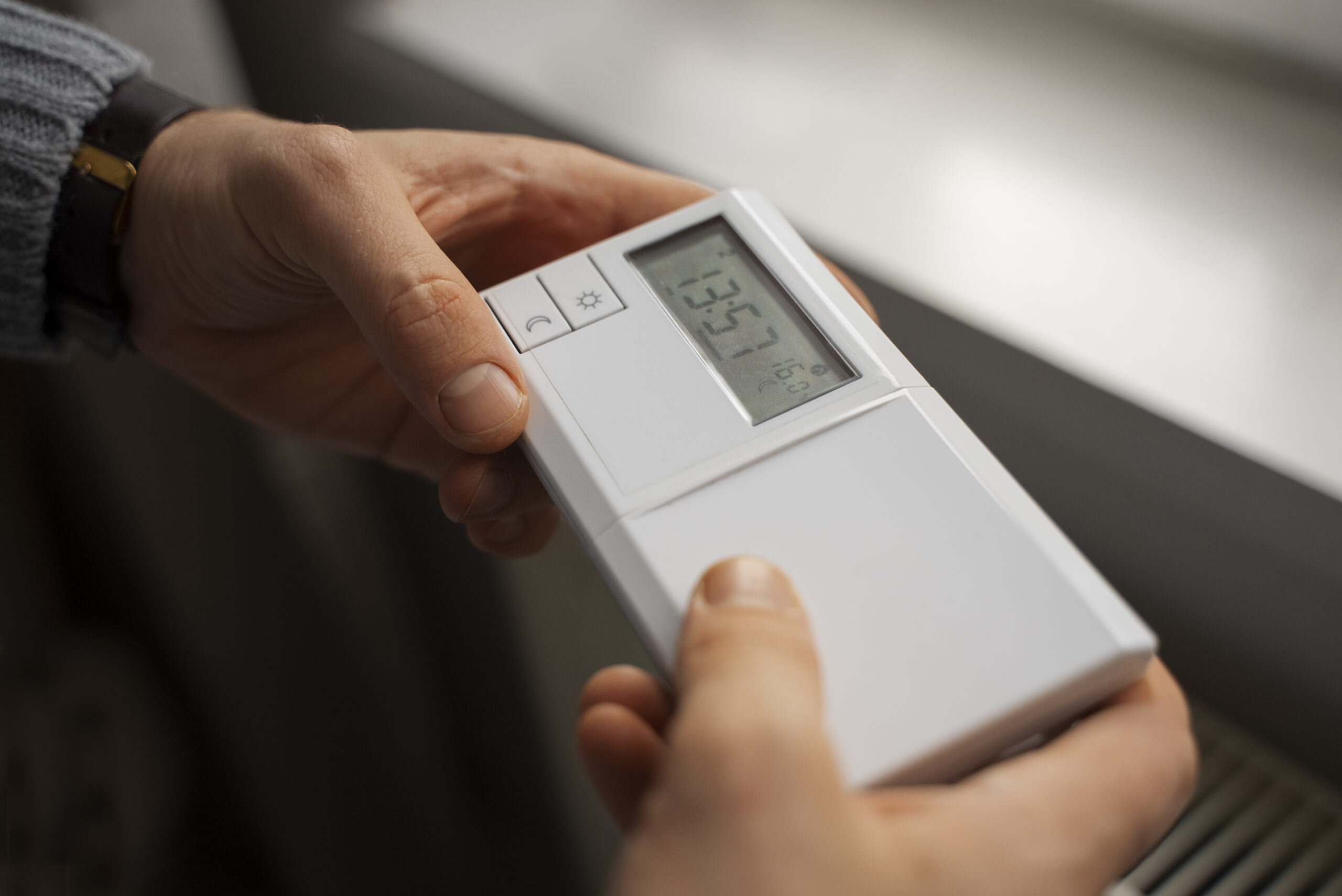 homme avec thermostat dans les mains